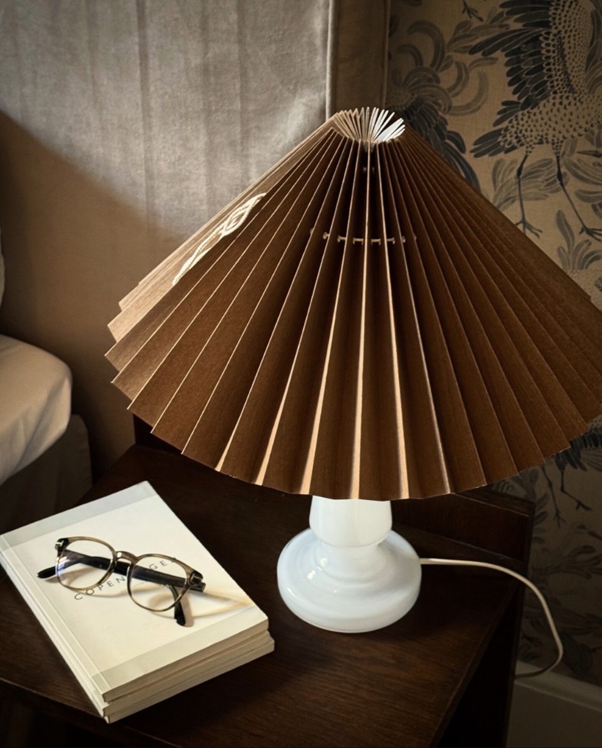 Bordlampe med brun plisseret skærm på natbord